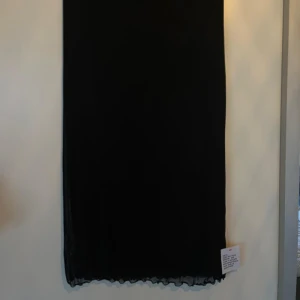 Svart mesh kjol strl 40 - Svart midikjol i mesh med underkjol och elastisk resår från ASOS. Midjan är prydd med rosett och detaljer längs kanten. Aldrig använd med etiketterna kvar. Nypris 369