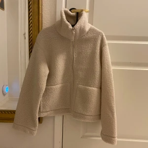 Ny pilejacka teddyjacka stl L - Ny med tags. Naturvit / ljusbeige i storlek L. Ganska liten i storlek. Vill du ha den oversize eller få plats med en tjocktröja under behöver du gå upp en storlek än vad du brukar ha. 