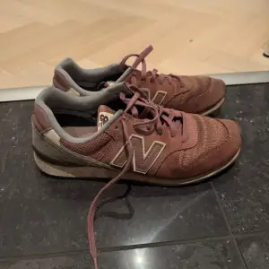 Säljer ett par New Balance sneakers i modellen 996 i en mörk rosa/lila färg. Använda mycket men har fortfarande mycket att ge.