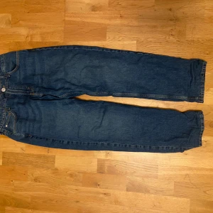 Blå jeans från H&M - Säljer ett par blå jeans från H&M i storlek EUR 164. De har en relaxed fit och justerbar midja, vilket gör dem superbekväma. Perfekta för vardagsbruk med en klassisk stil. Materialet är en blandning av bomull och polyester, vilket ger en skön känsla. Passar perfekt till både höst och vår!