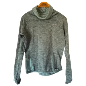 Grå polotröja från Nike - Säljer en snygg och bekväm grå polotröja från Nike. Perfekt för kyliga dagar med sin mjuka och stretchiga polyester. Tröjan har en diskret Nike-logga på bröstet och en praktisk dragkedja på sidan. Passar både till träning och vardag. 🖤