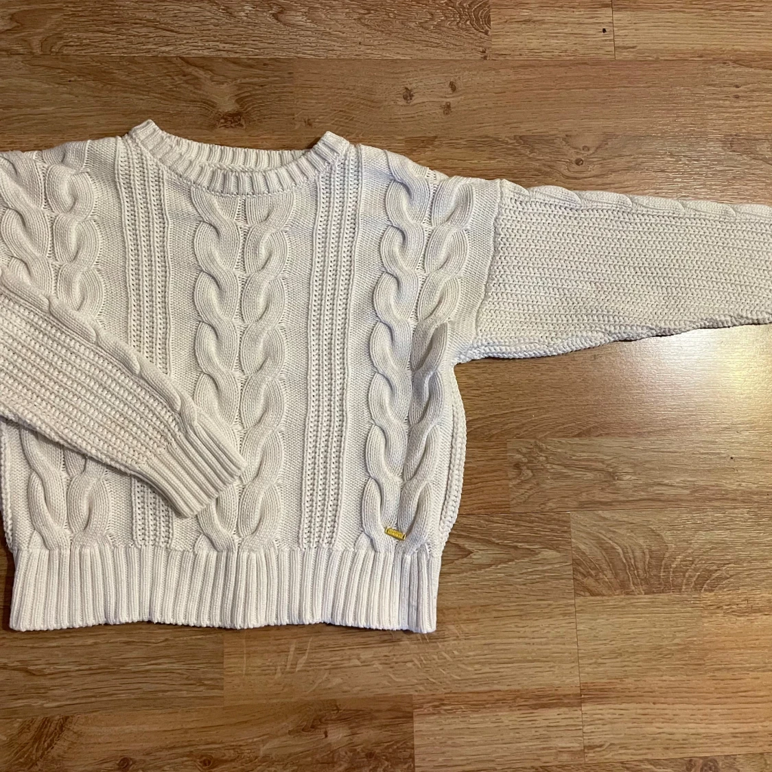 Vit stickad tröja med flätmönster