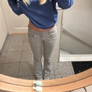 Grå byxor från Gina Tricot - Snygga grå byxor från Gina Tricot med låg midja och bootcut. Bra i längd för mig (är 170), supersnygga, storlek 164 och har knappar att spänna in och ut i midjan💘. 