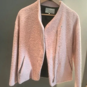Rosa jacka från Zara - Snygg rosa jacka från Zara med en mjuk och fluffig textur. Jackan har en stilren design med dragkedjor vid fickorna och en enkel knäppning framtill. Perfekt för att ge en färgklick till din outfit!