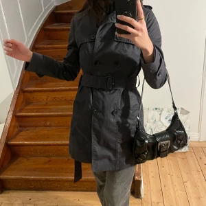 grå vattenresistent trenchcoat banana republic (nyskick!) - supersnygg mörkgrå trenchcoat från banana republic i vattenresistent material. endast använd 2-3ggr då den är lite liten för mig i axlarna (har vanligtvis storlek S)! kommer inte ihåg exakt nypris men köpt i USA för runt 2000kr, tror det är denna modell som inte säljs längre: https://bananarepublic.gap.com/browse/product.do?pid=361557002&vid=1