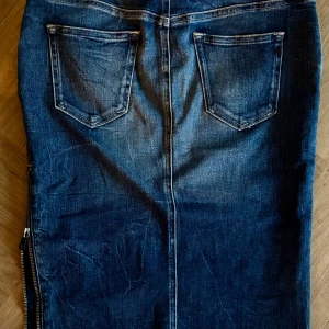 Jeanskjol från Replay - Snygg jeanskjol från Replay i klassisk blå denim. Kjolen har en dragkedja på sidan och femficksdesign med bälteshällor. Perfekt för en avslappnad stil.