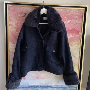 Svart teddyjacka med pälsdetaljer - Snygg svart teddyjacka med stora knappar och mjuka pälsdetaljer på krage och ärmslut. Lite nopprig men i bra skick. 