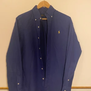 Blå skjorta från Ralph Lauren - Snygg blå Ralph Lauren skjorta 7/10 skick lite urtvättad men det är inget man tänker på. Nypris 1600. 