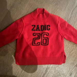 Röd stickad tröja från Zadig & Voltaire - Snygg röd stickad tröja från Zadig & Voltaire med texten 'ZADIG 26' på framsidan. Helt nyskick och superfin! Liten i storleken men passar 5-6 åring!❤️