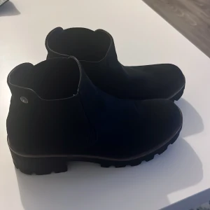 Svarta boots med grov sula - Snygga svarta boots med grov sula och elastiska paneler på sidorna för enkel på- och avtagning. Perfekta för en stilren look under höst och vinter.