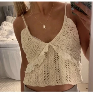 Jätte fin topp - Säljer en krämvit topp med spetsdetaljer och volanger framtill. Storlek S och perfekt för varma dagar på stranden eller när man ska på fest.