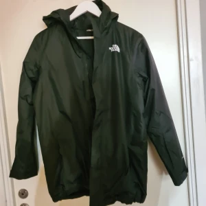 The North Face vinterjacka (ny,oanvänd) - Säljer en stilren svart vinterjacka från The North Face. Jackan har en praktisk huva och långa ärmar, perfekt för kalla vinterdagar men också kyliga regniga dagar. Den är tillverkad i ett slitstarkt material och har en den ikoniska loggan på bröstet och på skuldran. Funkar även för tjejer/kvinnor