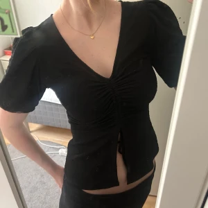 Svart kortärmad topp med knyt - Söt topp från bikbok! Knytning där nere,knappt använd! Storlek S