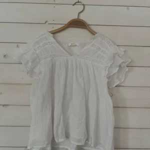 Vit blus med volangdetaljer - Supersöt blus från Gina Tricot. Använd ca 3 gånger.