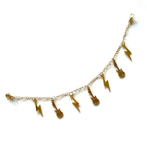 Guldfärgat accessoarsmycke - Guldfärgat handgjort accessoarsmycke med hängande blixtar och gitarrer ⚡️🎸Häng på väskan eller annan accessoar för en stilren, rockig touch till outfiten 🎸⚡️