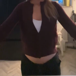 Vinröd kofta - Säljer en vinröd kofta med knappar framtill. Koftan är croppad och har långa ärmar, perfekt för en trendig look. Passar bra till både jeans och kjol. För fler bilder skriv❤️❤️❤️ Helt slutsåld på hemsidan!!