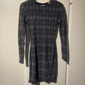 Svart glittrig klänning med geometriskt mönster - Snygg svart klänning med ett coolt geometriskt mönster i vitt. 