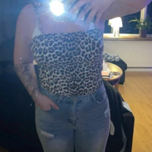 Leopardmönstrad tubtopp från H&M - Säljer en snygg leopardmönstrad tubtopp från H&M. Toppen har knytband vid axlarna och är perfekt för en trendig look. Den är i ett mjukt och bekvämt material.