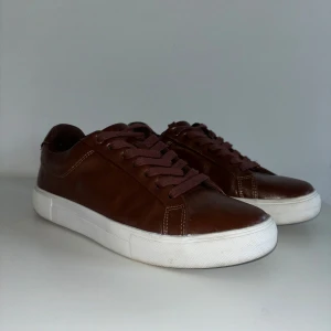 Bruna sneakers från Pier One - Sköna bruna sneakers i skinn med vita sulor och snörning. I princip helt nya, endast använda 1-2 gånger. Perfekt till våren. Nypris: 559 kr