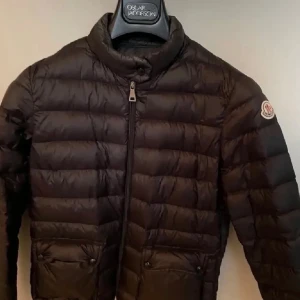 Svart dunjacka från Moncler Lans down  - Säljer min moncler lans down jacka som Tyvär inte kommer till användning. Den är i storlek 1 vilket motsvarar storlek S💞💞 Dragkedjan är lite trasig vid slutet men det går säkert att laga hos en skräddare, se bild 4, dragkedjan fungerar men ibland måste man trycka in ”trådflärpen”❤️, moncler påsen/dustbag i vindmatrial medföljer