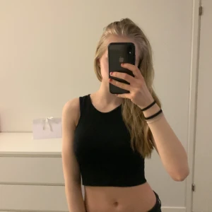 Svart ärmlös topp - Säljer en svart ärmlös topp från Bik Bok. Den är enkel och stilren, perfekt för varma dagar eller som lager under en jacka. Tillverkad i något som känns som ett sportigare sterila vilket är skönt under varma dagar. Finns två fläckar på undersidan men ingenting som överhuvudtaget syns på ovansidan. Hör av dig vid fler frågor💕