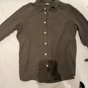 Olivgrön skjorta  - Säljer en olivgrön linne skjorta från Lindex i storlek 164. Väldigt skön till sommar. Kom med prisförslag 