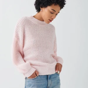 Ginatricot- Ljusrosa stickad tröja - Mysig ljusrosa stickad tröja med rund hals och långa ärmar. Perfekt för kyligare dagar med sin avslappnade passform och ribbade detaljer vid ärmslut och nederkant. Oanvänd! 