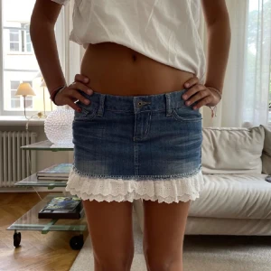 Jeanskjol med spetsdetalj - Säljer denna skitsnygga kjolen med en spetsvolang nertill. Storlek S. Jättefint skick. ANVÄND KÖP NU❤️❤️Säljer en valentino väska också💕💕