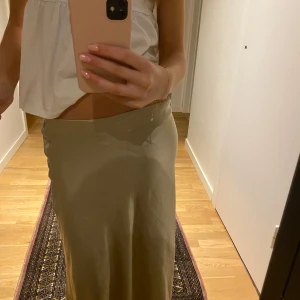 Lång kjol - Säljer min jätte fina champagne färgade silkes lång kjol då den har blivit lite för kort för mig i min smak. Jag skulle säga att den hade varit perfekt i längden för dom som är mellan 1,50-1,60 ish.