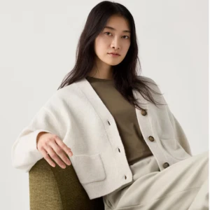 Beige kofta från Uniqlo - Säljer en stilren beige kofta från Uniqlo med knappar framtill och två praktiska fickor. Perfekt för lager-på-lager under kyligare dagar. Koftan har en klassisk design med ribbade kanter.