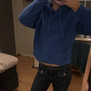 Blå hoodie - Säljer en blå hoodie med en bekväm passform och klassisk design. Den har en justerbar huva med dragsko och en stor ficka framtill. Perfekt för en avslappnad stil. Pris går att diskuteras vid snabb affär🥰