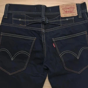 Svarta jeans från Levi's - Snygga svarta Levi's 511 jeans med klassisk design och kontrasterande sömmar. De har en normal passform och är tillverkade i slitstarkt material. Perfekta för en stilren look. 32x32