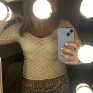 Vit spetsblus från Zara - Säljer en elegant vit spetsblus från Zara med v-ringning och långa ärmar. Perfekt för att ge en romantisk touch till din outfit. Blusen har ett vackert mönster och är både stilren och bekväm.