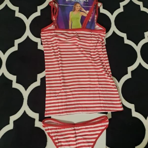 Röd- och vitrandig bikini - Snygg bikini med röd- och vitrandigt mönster. Toppen har smala axelband och en enkel design. Perfekt för en dag på stranden eller vid poolen.