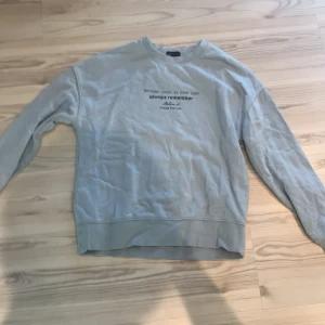 Ljusblå sweatshirt från Amisu - Säljer en ljusblå sweatshirt från Amisu med tryck på framsidan som säger 'Nothing loved is ever lost, always remember, believe it, change your life'. Tröjan har långa ärmar och en rund halsringning. 