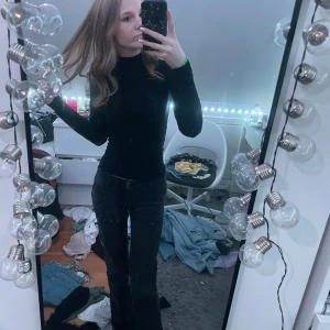 Svart långärmad polotröja - Säljer en stilren svart polotröja med långa ärmar. Perfekt för en elegant och enkel look. Tröjan är figurnära och passar bra till både jeans och kjol.