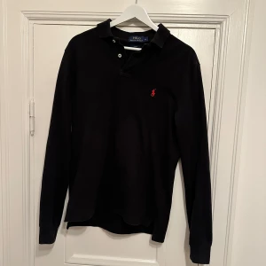 Svart långärmad pikétröja - Säljer en stilren svart långärmad pikétröja från Ralph Lauren. Hör av dig vid frågor!