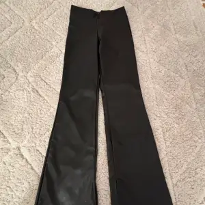 Stilrena svarta skin byxor från H&M. De har en bootcut-stil som passar både till vardags och finare tillfällen. 