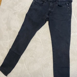 Svarta jeans från Replay - Snygga svarta jeans från Replay med en modern passform. De har en klassisk femficksdesign och en knappgylf. Perfekta för en stilren look.