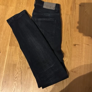 Svarta jeans från Tiger of Sweden - Snygga svarta jeans från Tiger of Sweden i modellen Sharp som är slim. De har en klassisk femficksdesign och en stilren look. Perfekta för en trendig och stilren outfit.