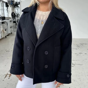 mörkblå kappa - snygg mörkblå kappa med knappar från designbysi. väldigt fin och passar till många outfits. bra skick!! perfekt till våren 