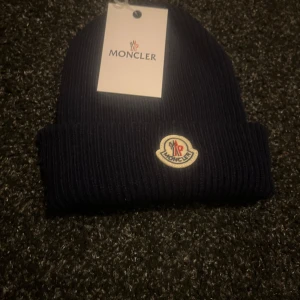 Mörkblå mössa från Moncler - Mössa som skulle varit present för min lillebror men tyckte ej om den därför säljs den. Helt oanvänd skriv gärna för ytterligare frågor. Mvh