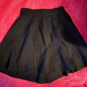 Fin svart kjol - Säljer denna kjol då den är för liten och aldrig kommer till användning! Den har skönt material, lite töjbar i midjan. Kedjan kan vara något segt att dra. Finns tecken på användning 