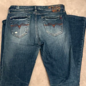 Jeans fårn replay  - MIDJEMÅTT: 39cm INNERBENSLÄNGD: 78cm Jeans med så coola detaljer ifrån weekday och bootcut 