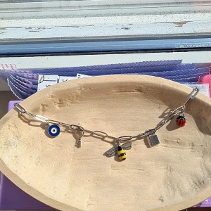 Silverfärgat halsband med berlocker - Charmigt silverfärgat halsband med flera unika berlocker. Perfekt för att ge en personlig touch till din outfit. Detta halsband är gjort för hand av mig.