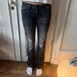 Svarta jeans från LTB - Snygga mörkgrå lågmidjade flared jeans från LTB med slitna detaljer på framsidan. De är i storlek W27 L34.
