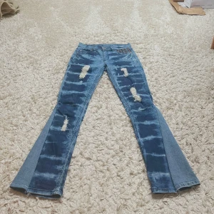 Blå bootcut jeans med slitningar - Snygga blå bootcut jeans med coola slitningar och nitar vid fickorna. De har en trendig tvättad look och är perfekta för en avslappnad stil. Omsydda till bootcut. Skriv om ni har frågor 💋