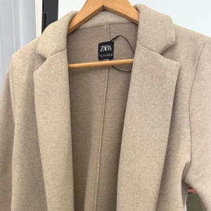 Kappa ifrån Zara  - En elegant och stilren kappa i en klassisk beige färg som passar till alla tillfällen. Den har en lätt oversize passform som ger ett modernt och avslappnat intryck, samtidigt som den är otroligt bekväm att bära. Storleken är L, men jag bär vanligtvis storlek S och valde medvetet denna storlek för att få till en snygg oversize look. Perfekt att matcha med både vardagliga och uppklädda outfits. Säljer kappan för 250kr men förhandling kan accepteras!