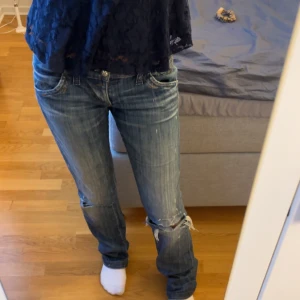Blå jeans från Miss Sixty - Snygga blå jeans från Miss Sixty med slitna detaljer. De har en låg midja och en bootcut-stil. Storlek 26/s och vintage