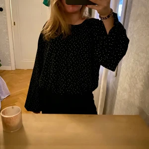 Svart prickig bus  - Skit snygg svart blus med små vita prickar! Säljer då den inte kommit till användning